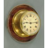 A Smiths astral brass cased ships type bulkhead style clock with mahogany mount.