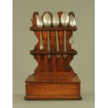 An 18th century oak spoon rack, complete with five pewter spoons and with hinged boxed base.