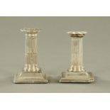 A pair of Mappin & Webb silver candlesticks, with fluted columns and beaded square stepped bases.