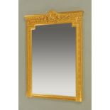 A large gilt framed mirror, with ribbon, wreath and foliate pediment and with moulded frame.