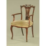 An Edwardian mahogany armchair, with pierced splat back, stuffover seat and raised on cabriole legs.