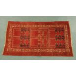 A large Eastern rug, principle colours red, black and beige. 210 cm x 122 cm.