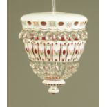 A milk glass overlay ruby tinted hanging light fitting, with faceted glass drops.