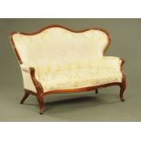 A Victorian walnut framed settee, with moulded exposed showframe and upholstered back,