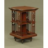 An Edwardian mahogany serpentine revolving bookcase. Height 85 cm, width 56 cm.
