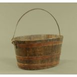 A 19th century oval oak metal bound barrel form planter, with iron loop handle.