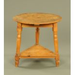 A 19th century pine circular cricket table, raised on angled turned legs. Diameter 78 cm.