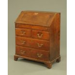 An 18th century oak bureau, with crossbanded flap opening to a stepped fitted interior with well,
