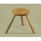 A 19th century milking stool, circular with three angled legs. diameter 22 cm, height 26 cm.