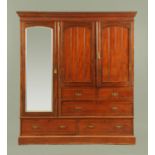 An Edwardian Maples walnut wardrobe, with detachable moulded cornice above a series of cupboards,