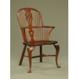 A yew wood Windsor armchair, with pierced splat shaped seat and crinoline stretchers.