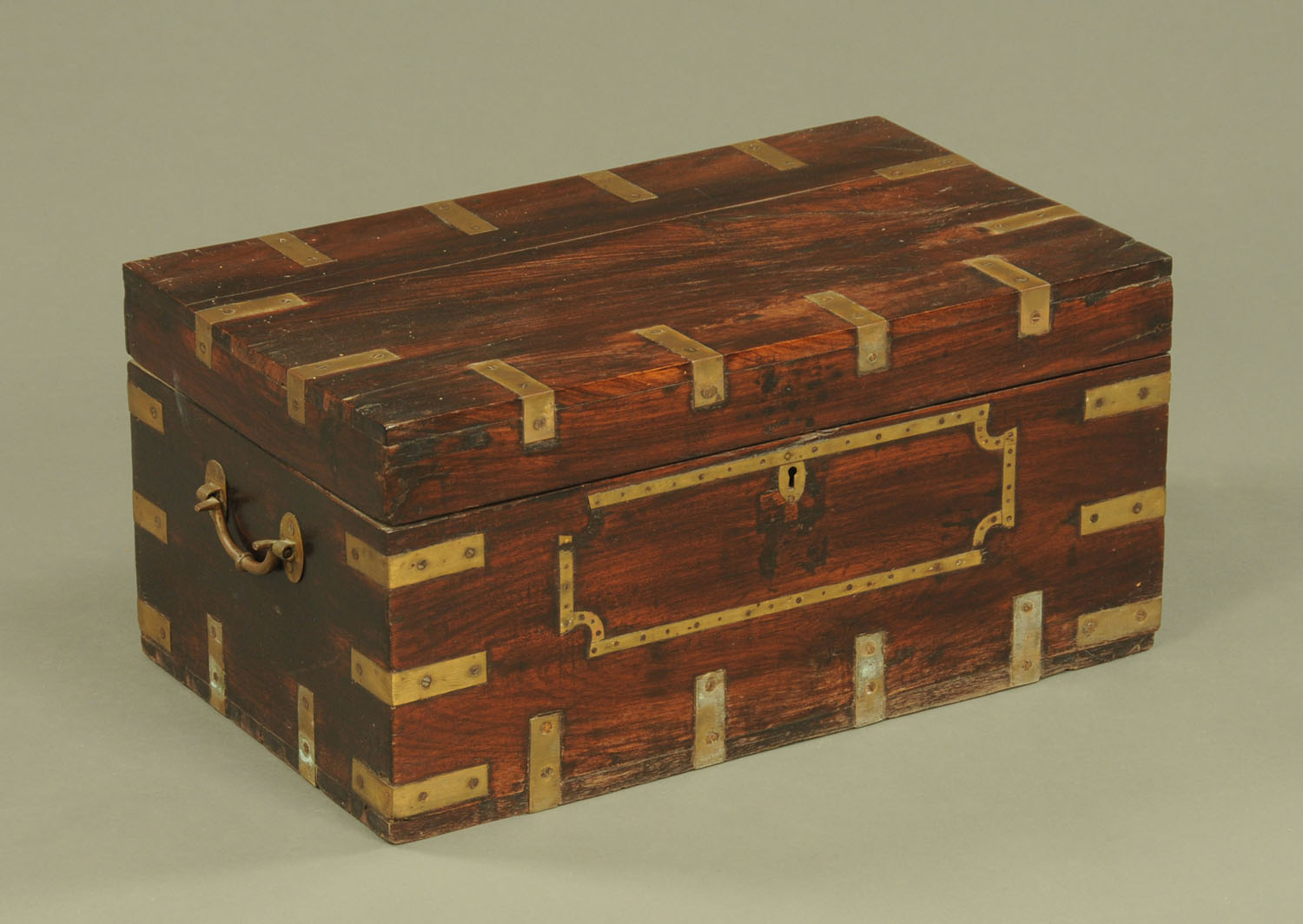 An Indian brass bound rectangular casket, with carrying handle to either side.