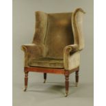 A George IV mahogany wing easy chair in the manner of Gillows, with serpentine wings, loose cushion,
