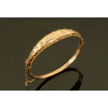 A 9 ct gold bangle, with safety chain, 7 grams.