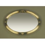 An Art Deco metal framed oval mirror, bearing label to rear "Hotel Metropole, Bruxelles".