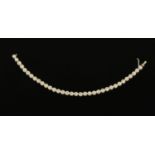 An 18 ct white gold line bracelet, set with diamonds weighing +/- .72 carats.