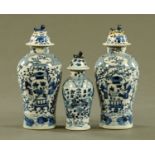 A pair of Chinese blue and white lidded vases, and another similar but smaller,