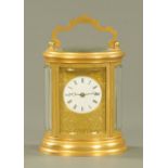 An Edwardian oval brass carriage clock,