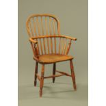 A 19th century elm Windsor armchair, with solid seat, turned legs and stretchers.