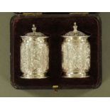 A pair of silver condiments, foliate embossed, Chester hallmarks for 1894, maker Cohen & Charles.