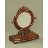 A Victorian mahogany circular mirror, with carved frame and bowfronted stand.