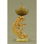 An Art Nouveau gilt brass lamp base, with iridescent glass font and raised on an onyx base,