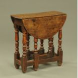 An 18th century oak drop leaf gate leg table, small size, with turned supports,