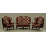 A three piece oxblood leather lounge suite, comprising settee and two chairs,