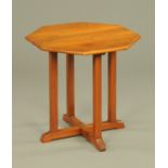 An Arts and Crafts octagonal occasional table, raised on four legs with cross stretchers.