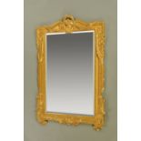 A large gilt framed mirror, wood and composition, with bevelled glass and in the classical style.