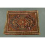 An antique Persian rug, with fringed ends,