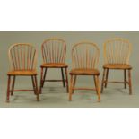 A set of four early 19th century elm dining chairs, with arched stick backs,