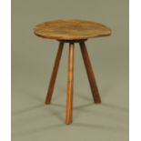 An early 19th century country oak circular occasional table, with three angled legs.