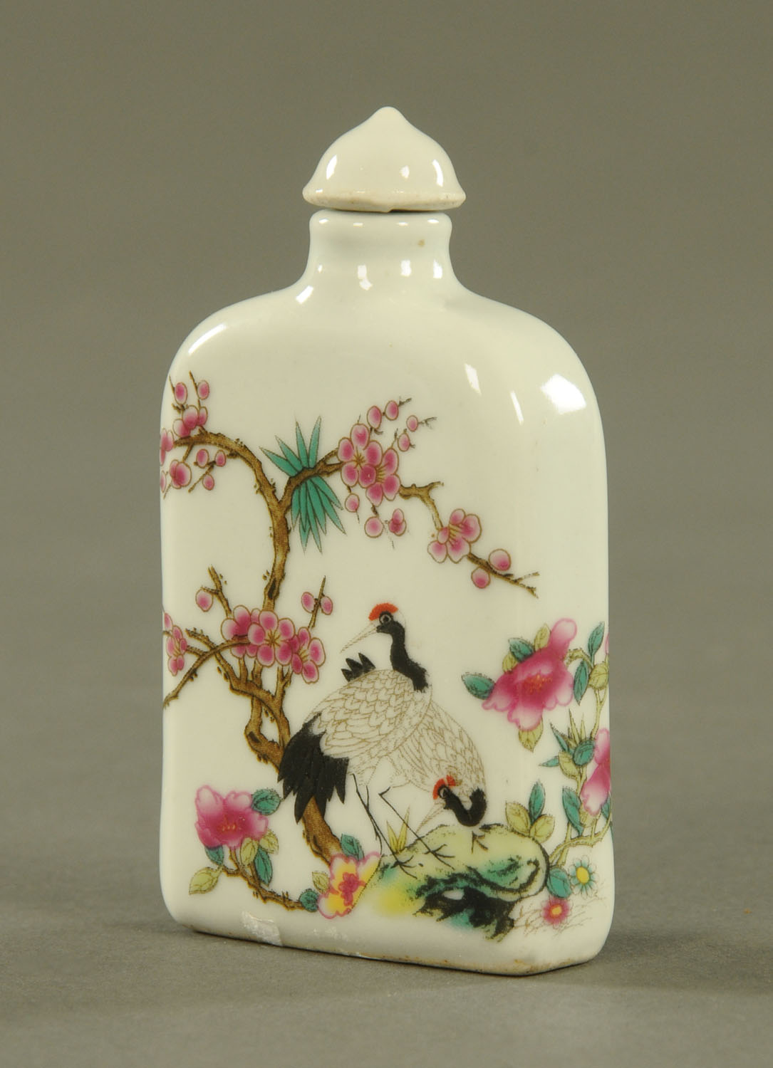 A Chinese opium bottle, polychrome decorated with birds, blossom and branches. Height 9 cm.