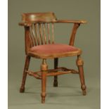 A Victorian office armchair, with upholstered seat and raised on turned legs.