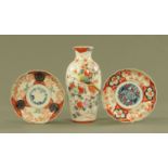 A Japanese Meiji period vase, height 31 cm, and two Imari plates, each diameter 22 cm.