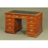 An Edwardian pedestal desk, with dark leather writing surface,