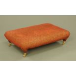 A Victorian style rectangular footstool, with turned legs and brass castors.