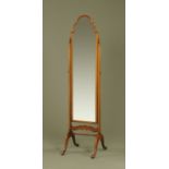 A mahogany framed cheval mirror, with arched top, narrow form and raised on four downswept legs.