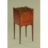 A George III mahogany bedside cabinet, with wavy gallery,