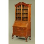 A mahogany bureau bookcase, circa 1920 with swans neck pediment above a pair of glazed doors,