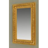 A gilt framed bevelled glass mirror, with composition and giltwood moulded frame. 151 cm x 90 cm.