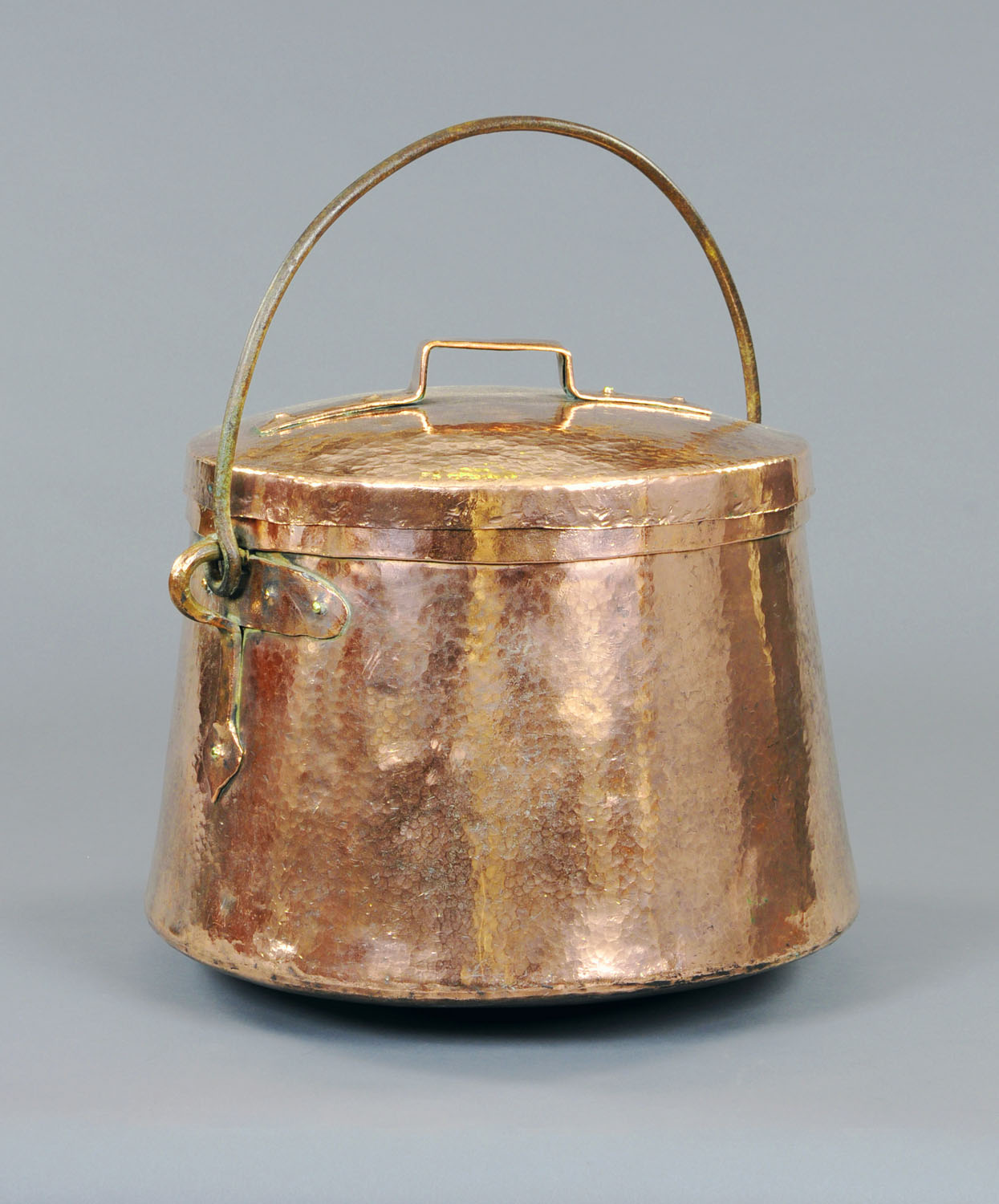 A large 19th century planished copper lidded coal or log box, with iron loop handle.