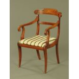 A Regency mahogany armchair, with drop in seat and raised on sabre front legs.