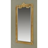 A gilt framed bevelled glass tall mirror, with moulded composition frame and with shell,