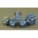 Four Chinese ginger jars and a moon flask, all blue and white and decorated with blossom.