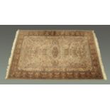 A Persian design woollen fringed carpet, principal colours beige, blue and green,