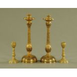 A pair of enamelled brass candlesticks, height 29 cm, and a smaller pair, height 12 cm.