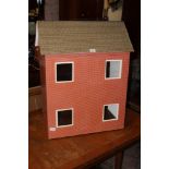 A vintage dolls house, formed as a red b