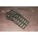 A pair of green painted metal car ramps